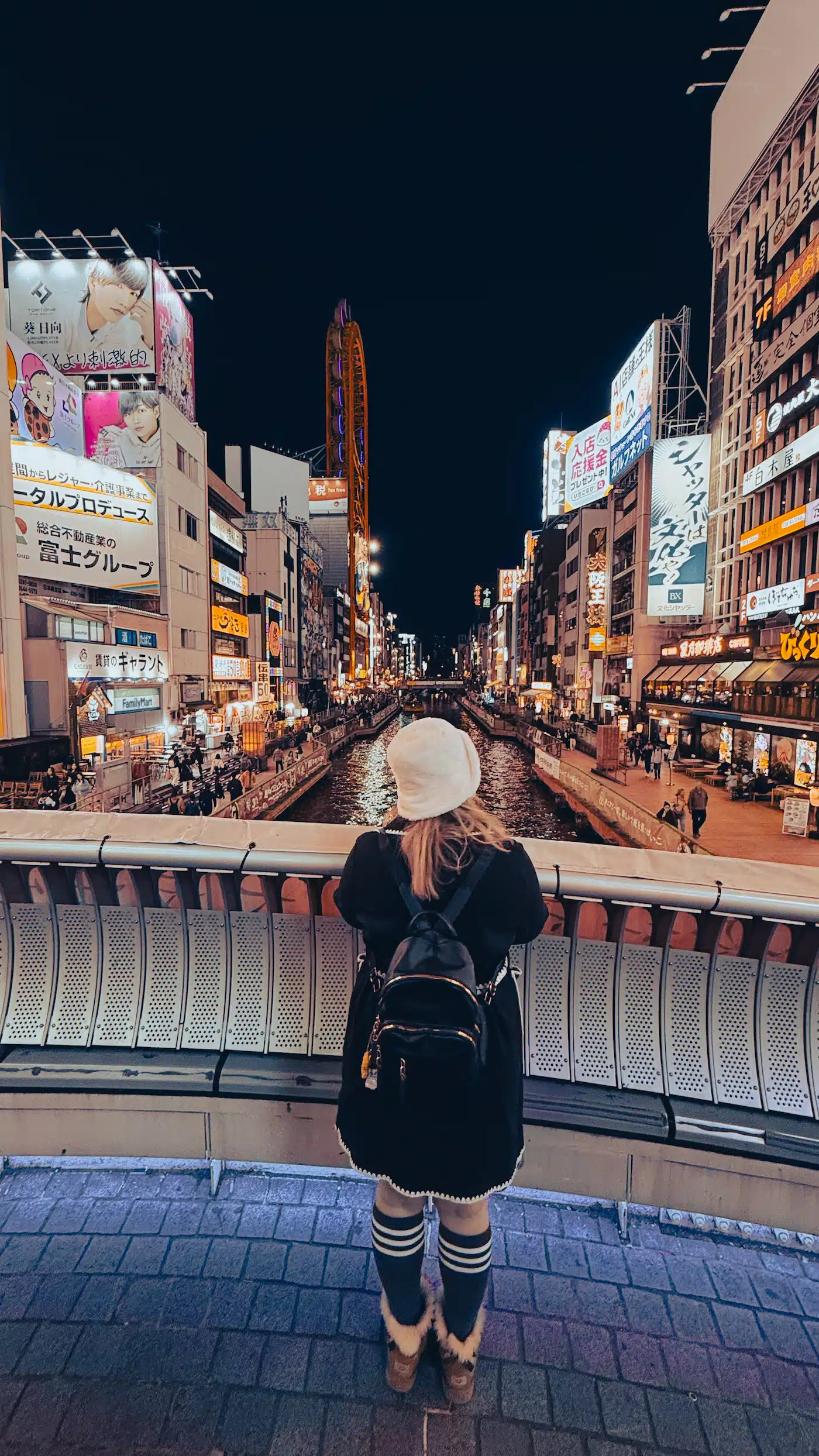 Girl standing on a Bridge overlooking Dontonbori in Osaka, Japan